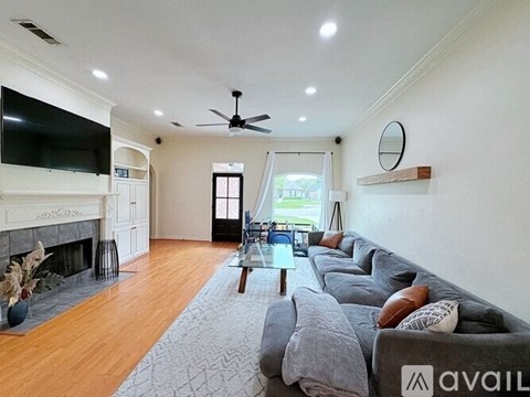 A living room with a grey sofa and a fireplace.