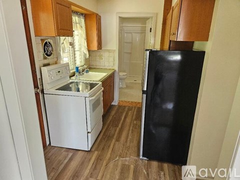 A kitchen with a black fridge, white oven and sink.