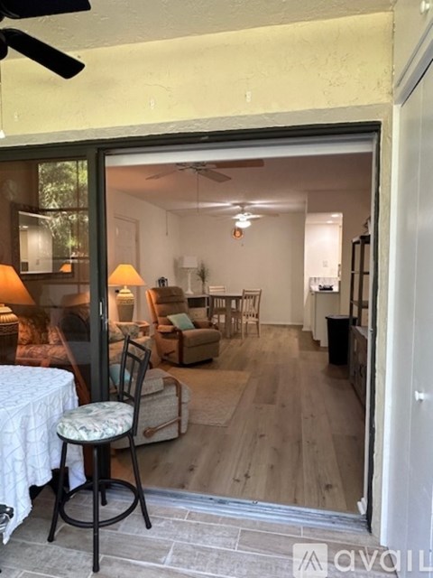 A living room with a chair and a table in front of a glass door.