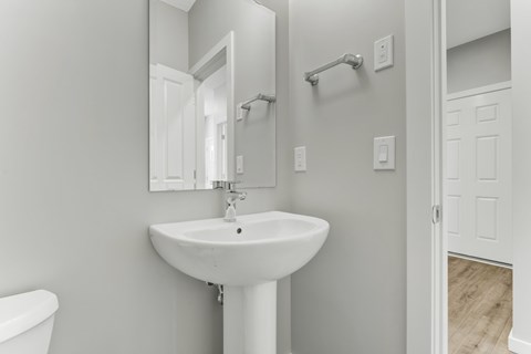 A white bathroom sink with a mirror above it.