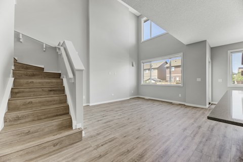 A spacious living room with a staircase leading to the upper floor.