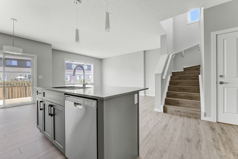 A modern kitchen with a stainless steel dishwasher and a white countertop.