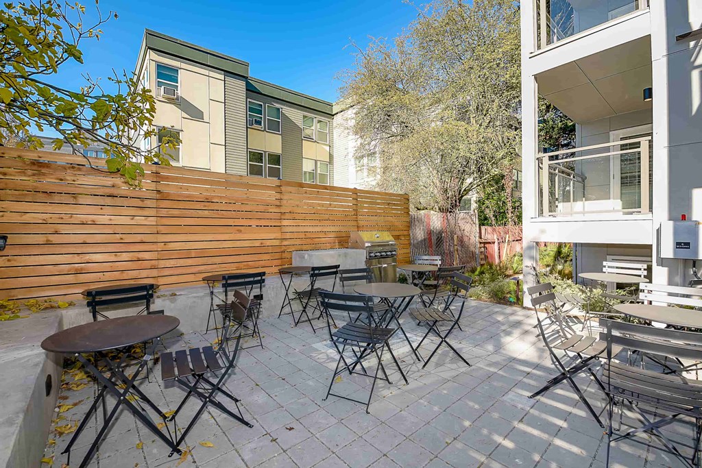 A patio with a table and chairs is surrounded by a wooden fence.