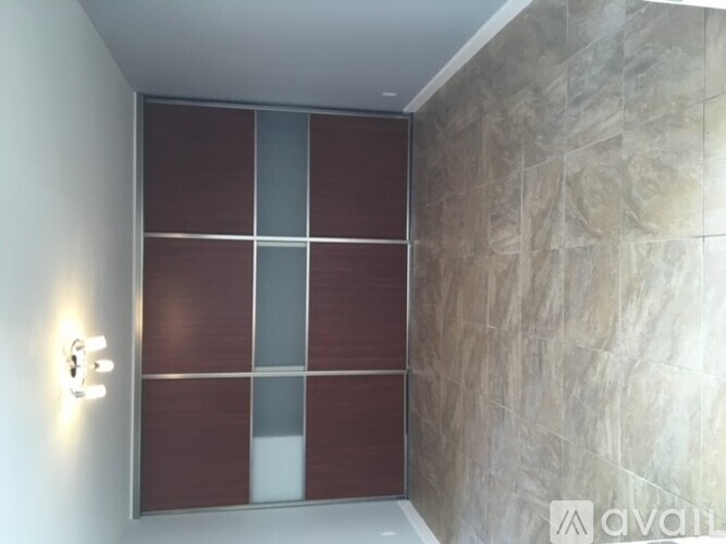 A wall with a light switch and a wall panel with a brown and beige color scheme.