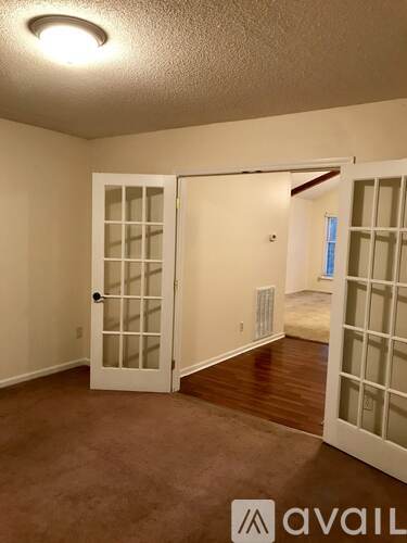 A room with a carpeted floor and a white door with a glass panel.