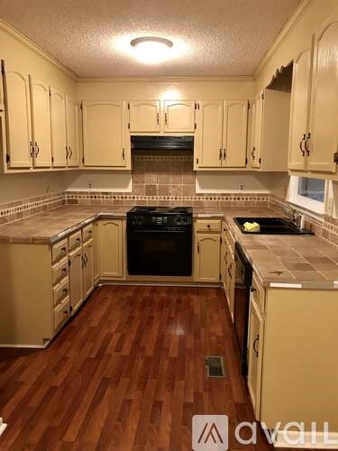 A kitchen with wooden floors and cabinets.