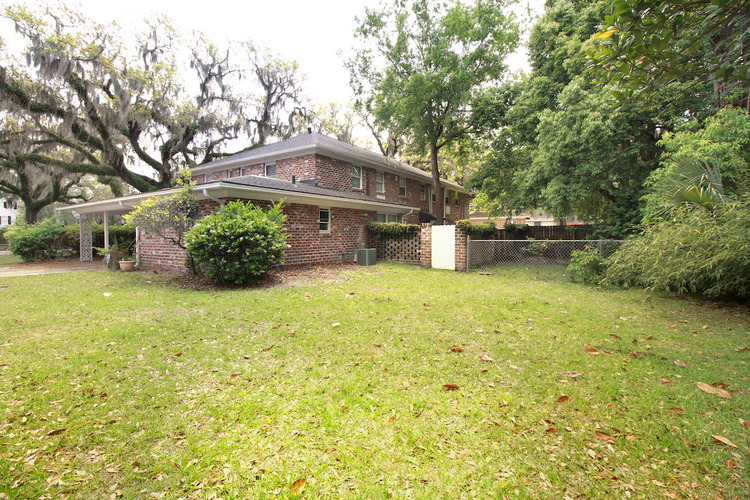 A house with a lawn and trees in the background.