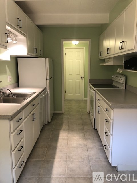 A kitchen with white appliances and cabinets.