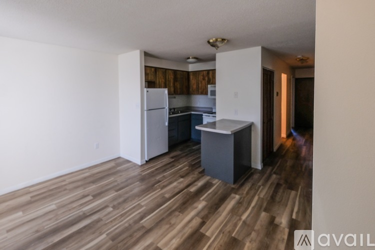 A kitchen with a white refrigerator, a white island, and a white cabinet.