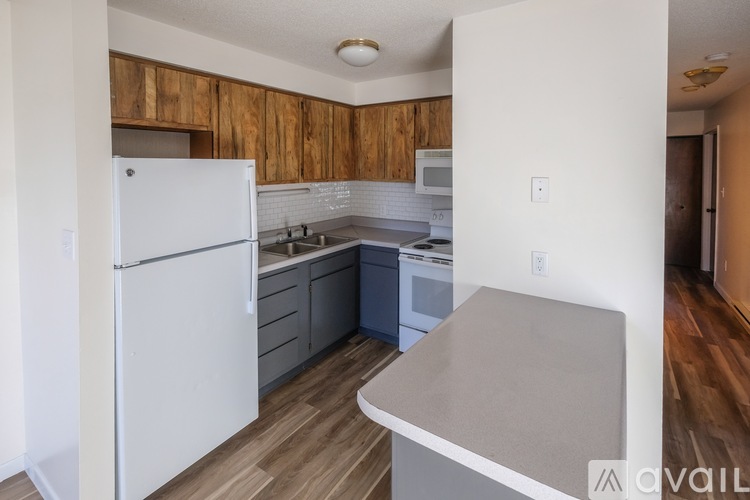 A kitchen with a white fridge and wooden cabinets.