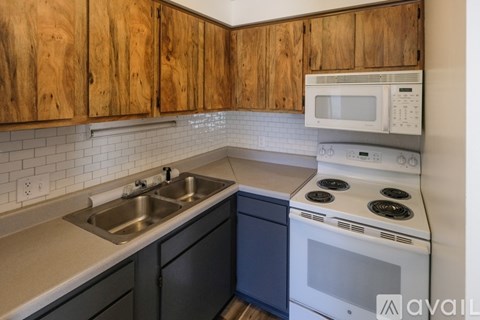 A kitchen with wooden cabinets and a white stove.