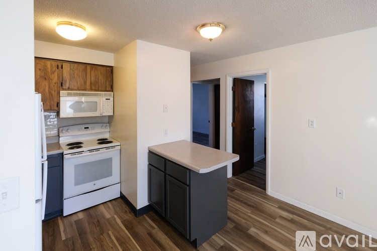 A kitchen with a white fridge, stove, and microwave.