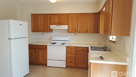 A kitchen with wooden cabinets and white appliances.