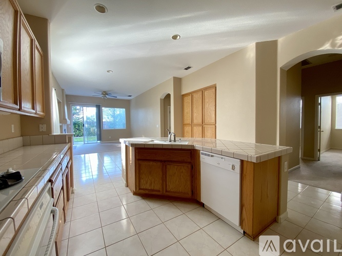 A kitchen with wooden cabinets and a white dishwasher.