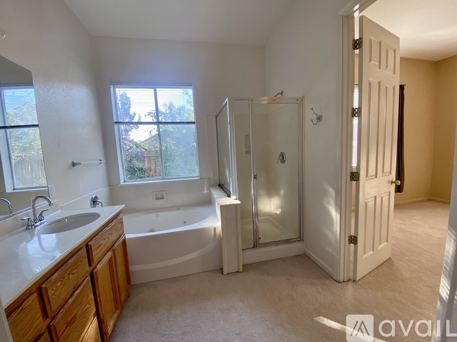 A bathroom with a tub, sink, and shower.