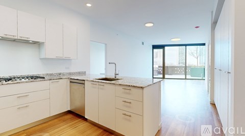 A kitchen with white cabinets and a marble countertop.
