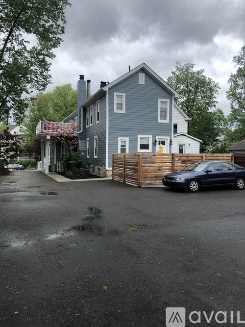 A blue house with a car parked in front.