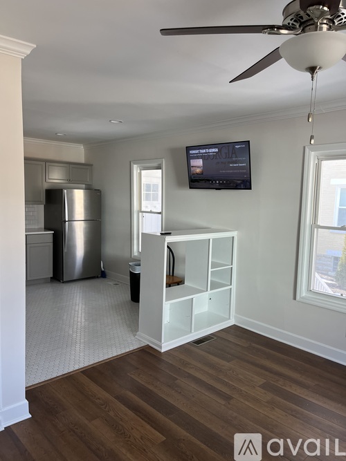A living room with a television and a ceiling fan.