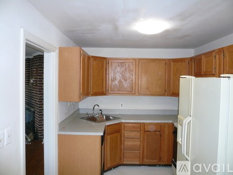 A kitchen with wooden cabinets and a white fridge.