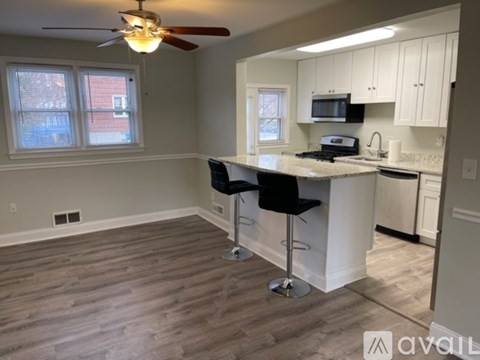A kitchen with a bar stool and a fan.