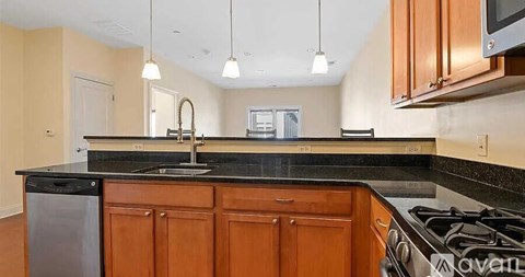 A kitchen with wooden cabinets and a black countertop.