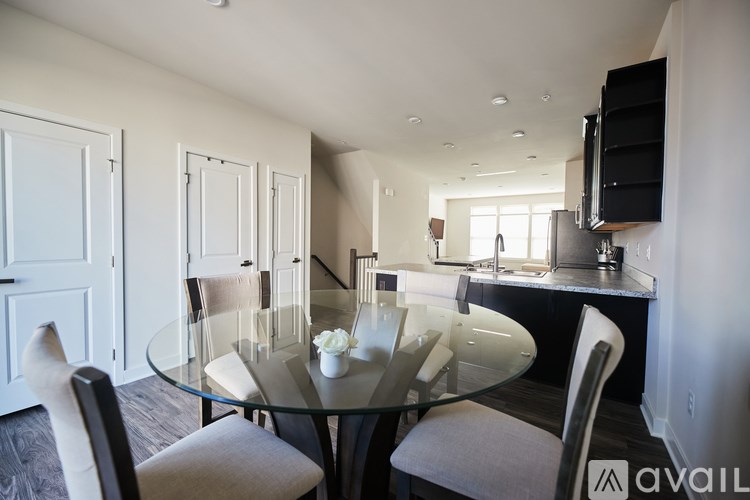 A modern dining room with a glass table and chairs.