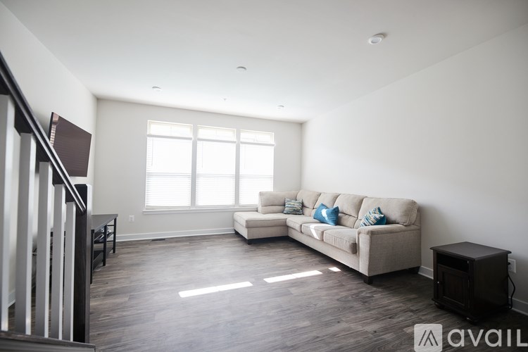 A living room with a couch, a chair, and a television.