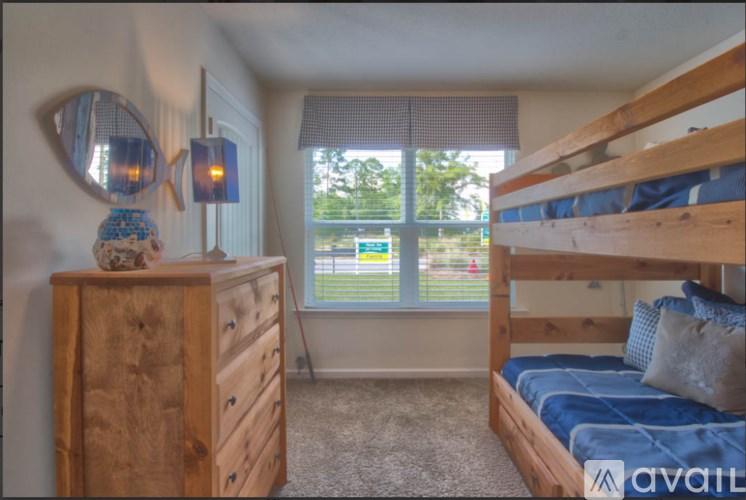 A bedroom with a bunk bed and a dresser with a mirror.