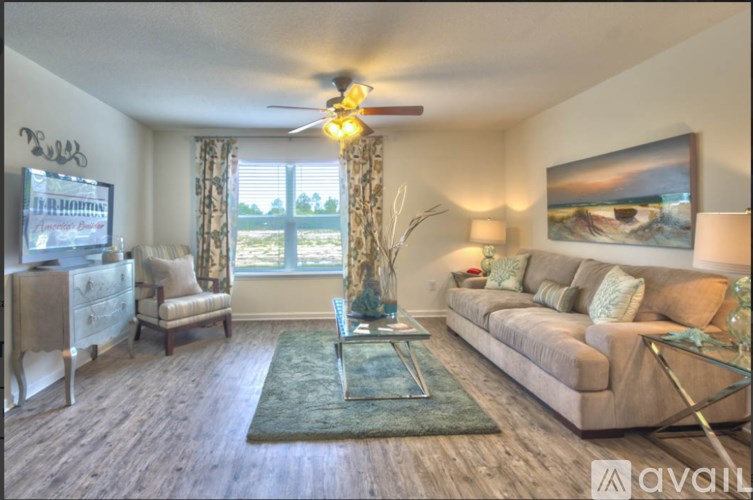 A living room with a couch, chair, and a ceiling fan.