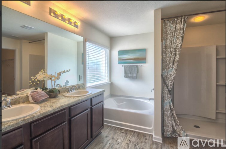 A bathroom with a tub, sink, and mirror.