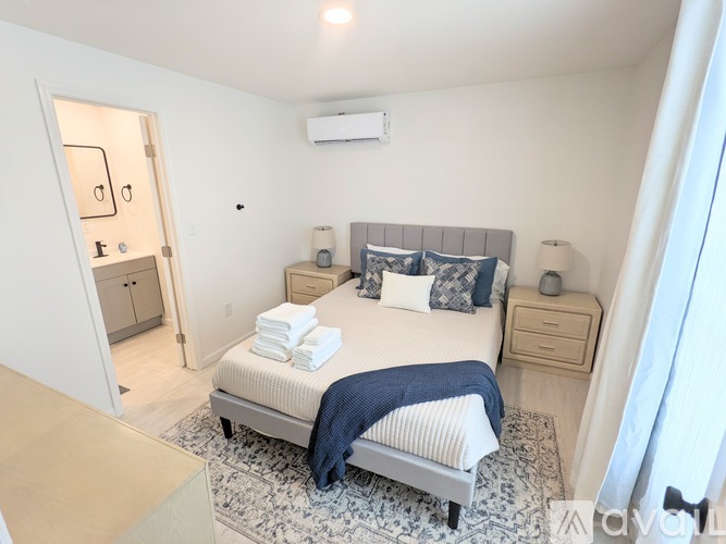 A bedroom with a bed, nightstand, and a dresser.