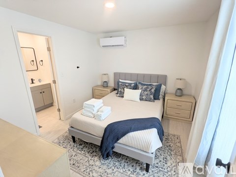 A bedroom with a bed, nightstand, and a dresser.