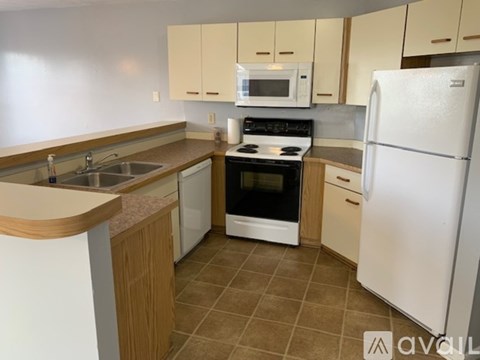 A kitchen with a white refrigerator, white oven, and white microwave.
