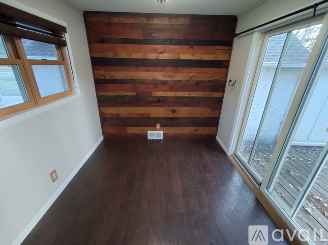 A room with wooden wall and sliding glass door.