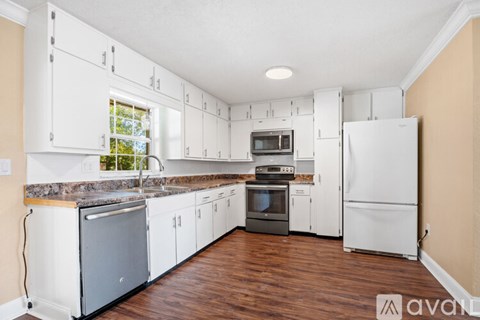 A kitchen with white cabinets and appliances.