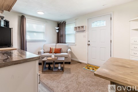 A living room with a couch, a coffee table, and a television.