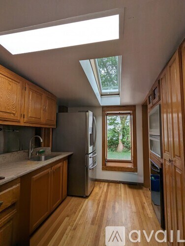 A kitchen with wooden cabinets and a skylight.