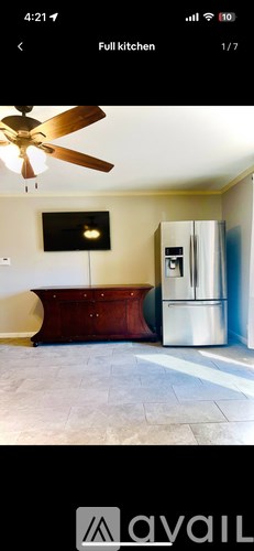 A kitchen with a ceiling fan and a refrigerator.