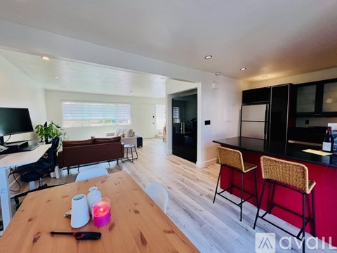 A modern kitchen with a wooden table and bar stools.
