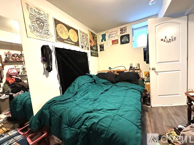 A bedroom with a bed covered in a green sleeping bag.