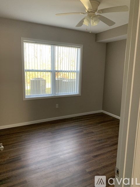 A room with a window and a ceiling fan.