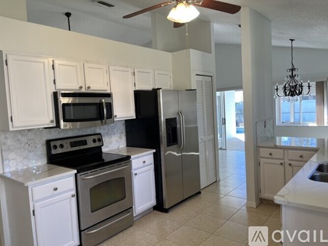 A kitchen with white cabinets and stainless steel appliances.