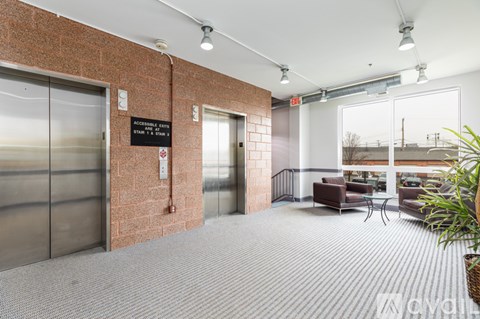 A hallway with a brick wall and a glass door with a sign that says "Accesible Fire Rms".