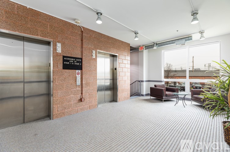 A hallway with a brick wall and a glass door with a sign that says "Accesible Fire Rms".