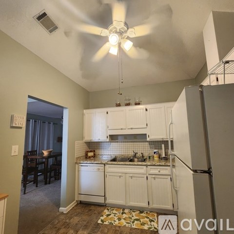 A kitchen with white cabinets and a ceiling fan.