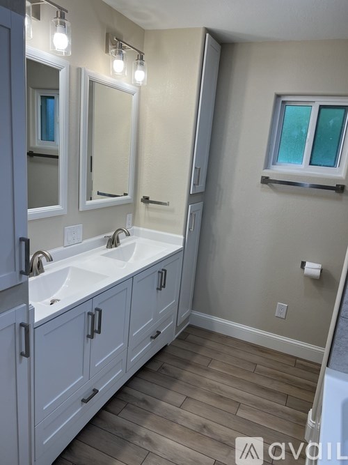 A bathroom with a white vanity and a window.