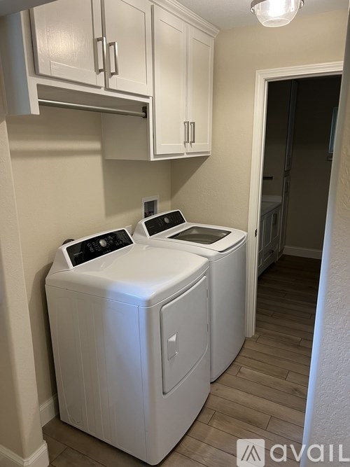A white washing machine and dryer in a laundry room.