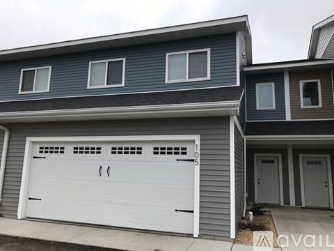 A two-story house with a white garage door.