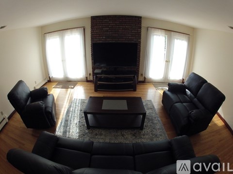 A living room with black furniture and a fireplace.
