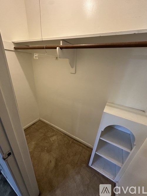 A white kitchen cabinet with a brown handle and a white shelf with a hole in the middle.
